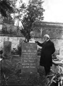 发士牧师的墓碑，碑旁站立者为武林吉牧师（来源：维基共享资源）